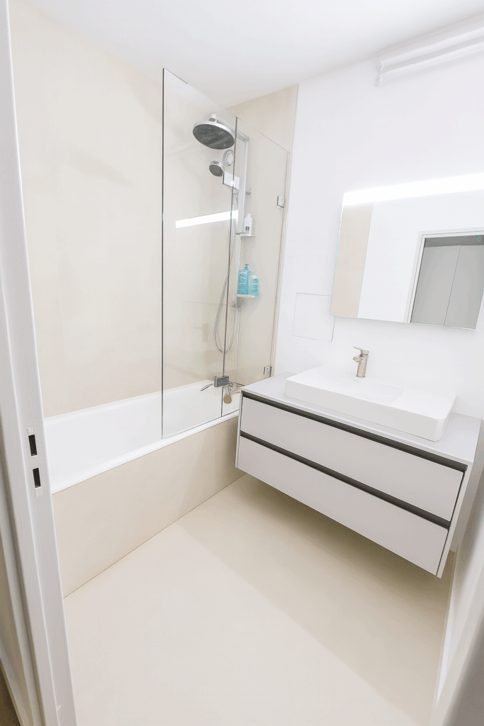 Salle de bain rénovée à Paris avec carrelage grand format Living Ceramics, meuble suspendu et paroi de douche en verre – MAKRENO rénovation intérieure