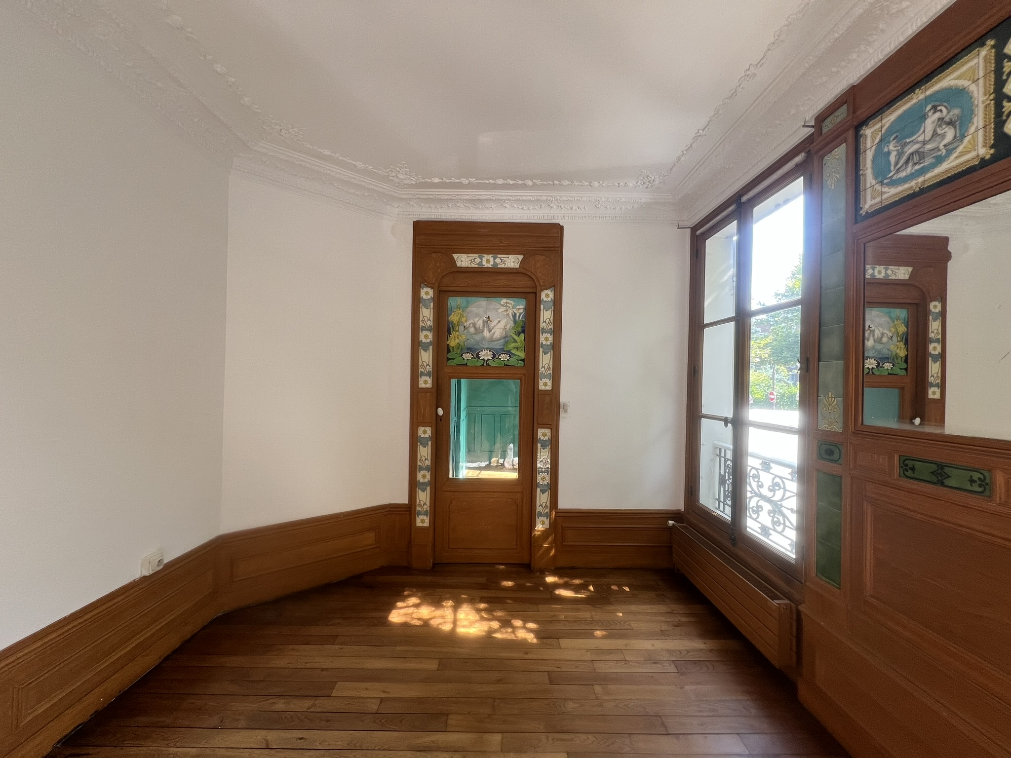 Séjour rénové d’une maison de style château à Enghien-les-Bains – murs restaurés, boiseries préservées et moulures d’origine mises en valeur