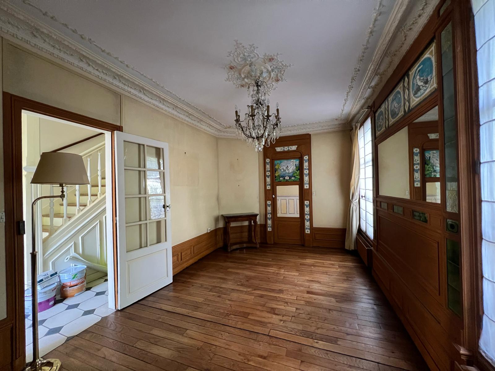 Cette photo présente le séjour avant rénovation dans une maison de caractère à Enghien-les-Bains, inscrite dans un style château classique.
L’espace se distingue par ses moulures d’époque, une cheminée en marbre sculpté, ainsi que des faïences murales vertes décoratives typiques de la fin du XIXᵉ siècle.
Le projet de rénovation entrepris par MAKRENO vise à restaurer et moderniser cet espace de vie, tout en préservant les éléments patrimoniaux : corniches, plafonds à rosace, menuiseries et revêtements nobles.
Cette étape “avant travaux” illustre l’état initial du lieu, marqué par le charme de l’ancien et la richesse de ses détails décoratifs, avant la mise en œuvre des travaux d’enduit, de peinture et de restauration fine.